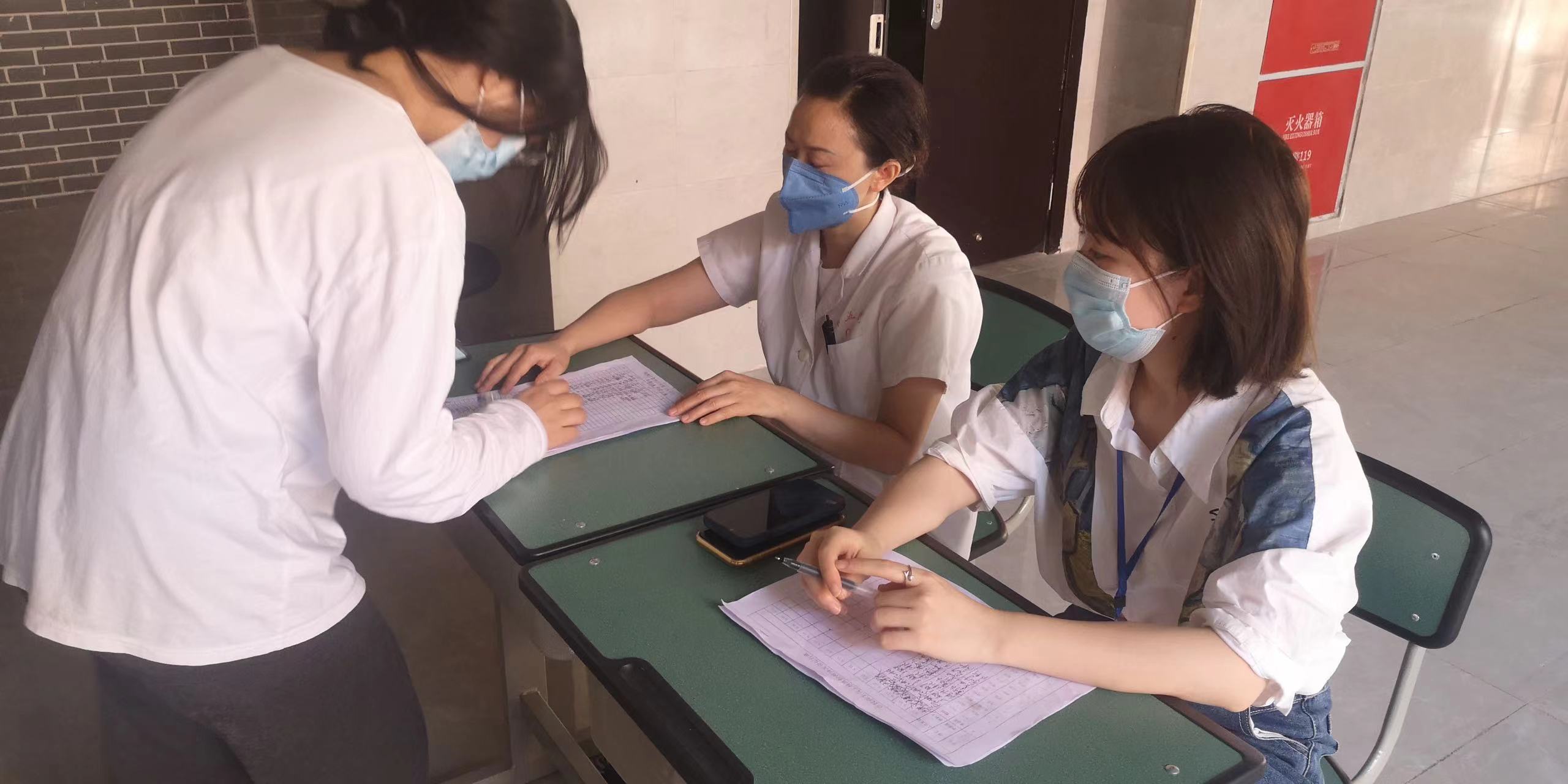 团委干部、医务室工作人员为学生核酸检测登记信息.jpg